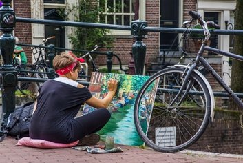 Artist painting scenic canal view in Amsterdam