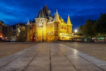 Illuminated historic building in Amsterdam with evening sky background