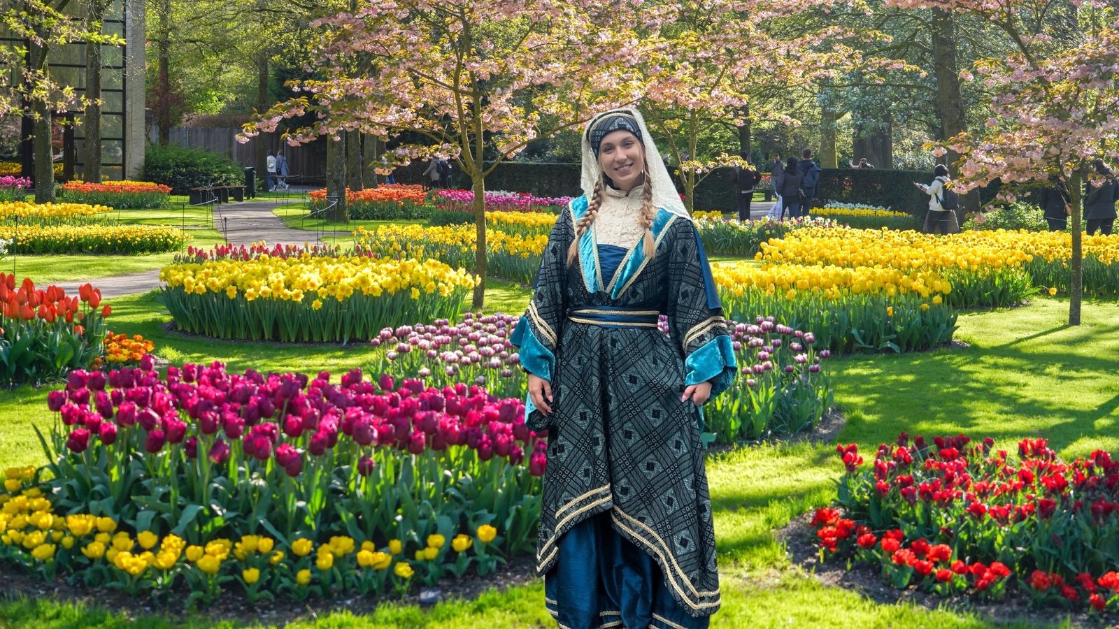 Woman in traditional attire amidst vibrant garden